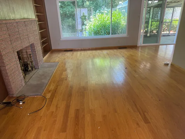 wooden floor in an empty room with a fireplace