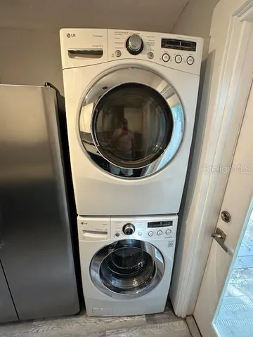 a view of a backyard with wooden fence and a large tree