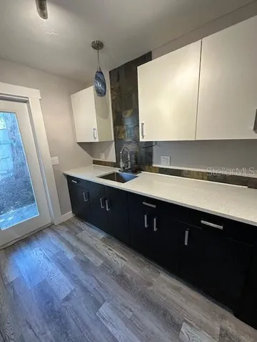 a kitchen with kitchen island granite countertop a sink stove and refrigerator
