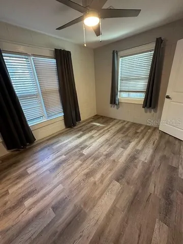 a view of a livingroom with a flat screen tv a ceiling fan and window