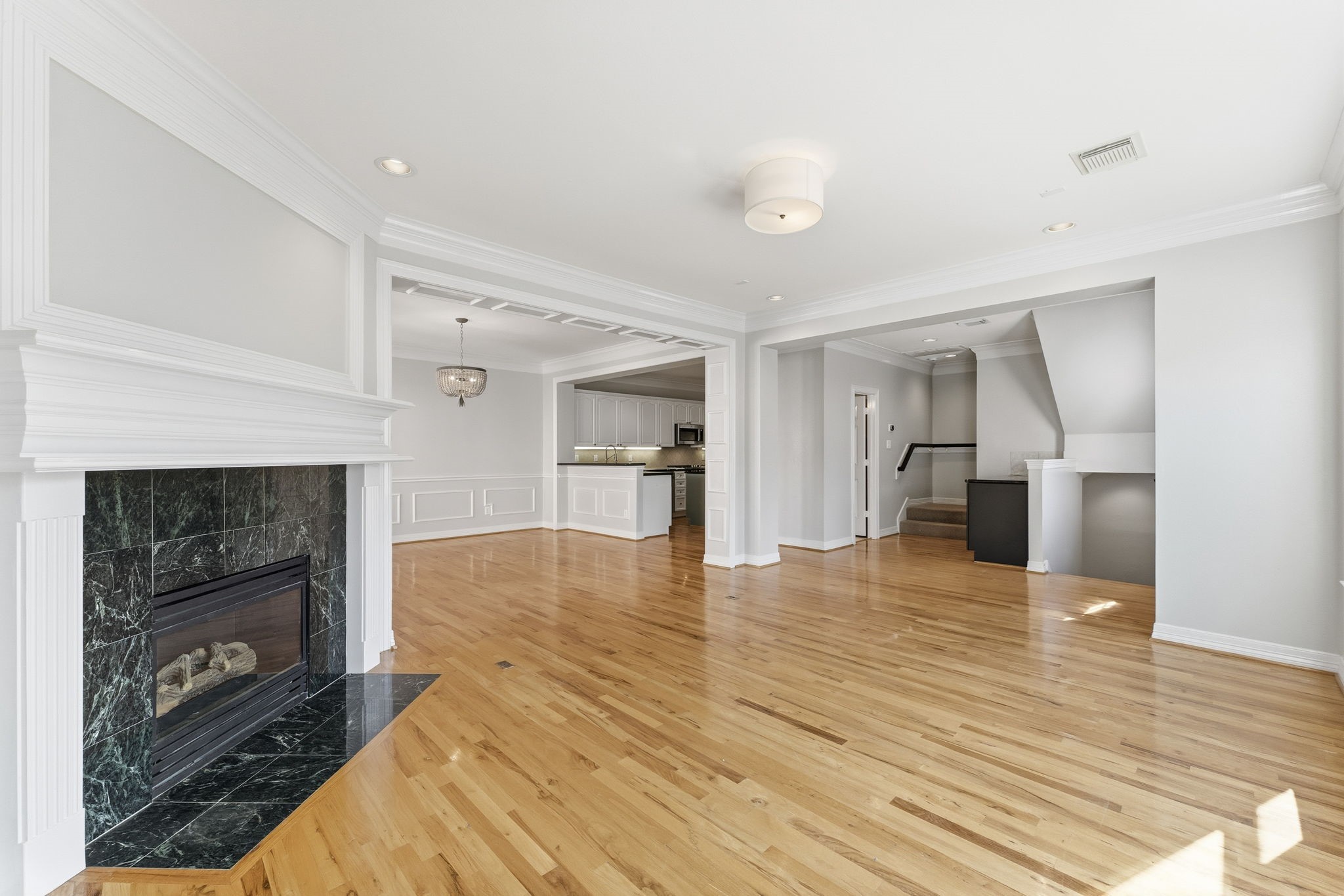 827 Rosine Street Houston, TX 77019 - Photo 21 of 50 This spacious living area features hardwood floors, a stylish fireplace, and abundant natural light. It seamlessly connects to a modern kitchen, ideal for entertaining.