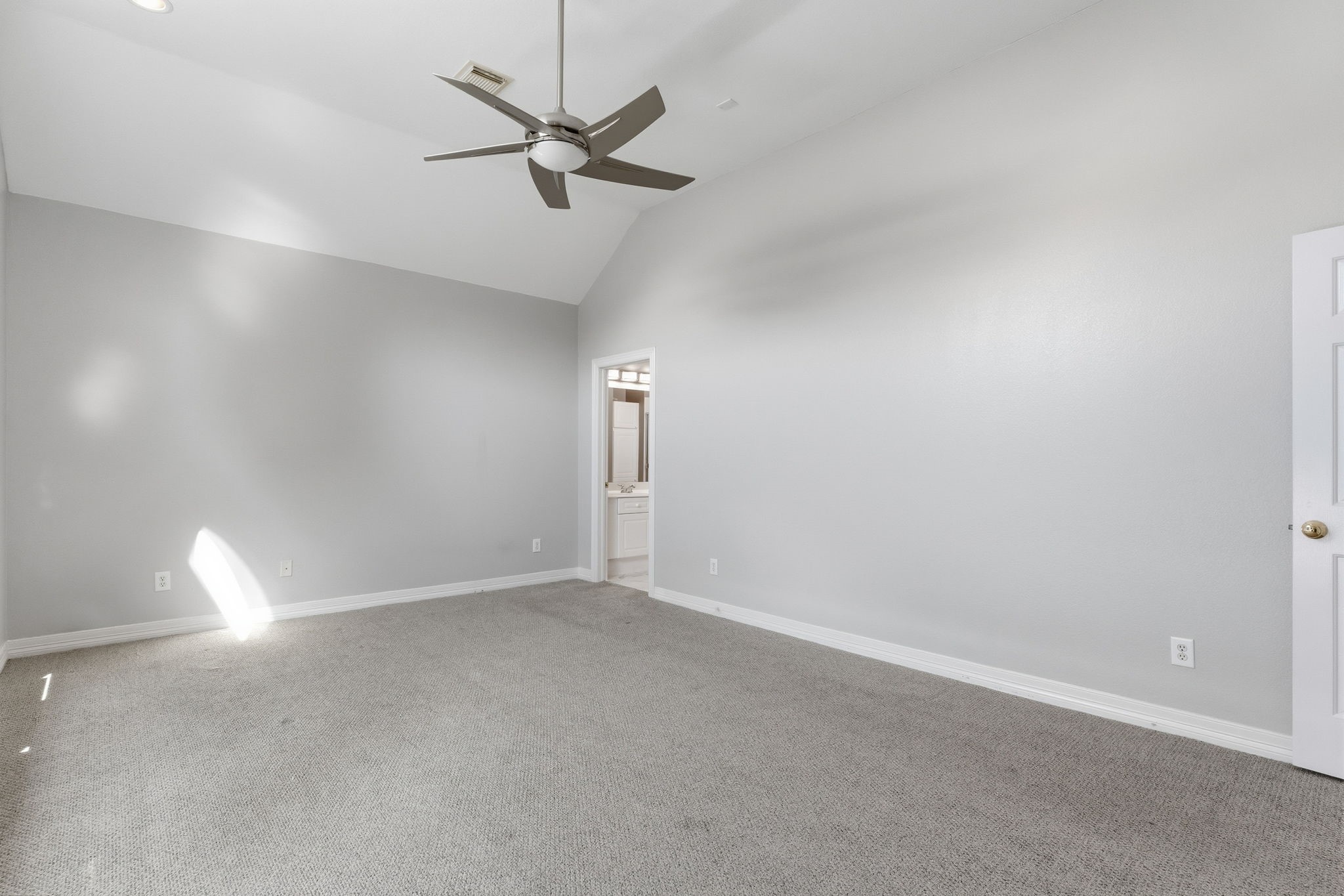 827 Rosine Street Houston, TX 77019 - Photo 37 of 50 This spacious room features neutral walls and carpeting, a modern ceiling fan, and ample natural light. It includes an entryway to an adjacent bathroom, making it ideal for a master bedroom.
