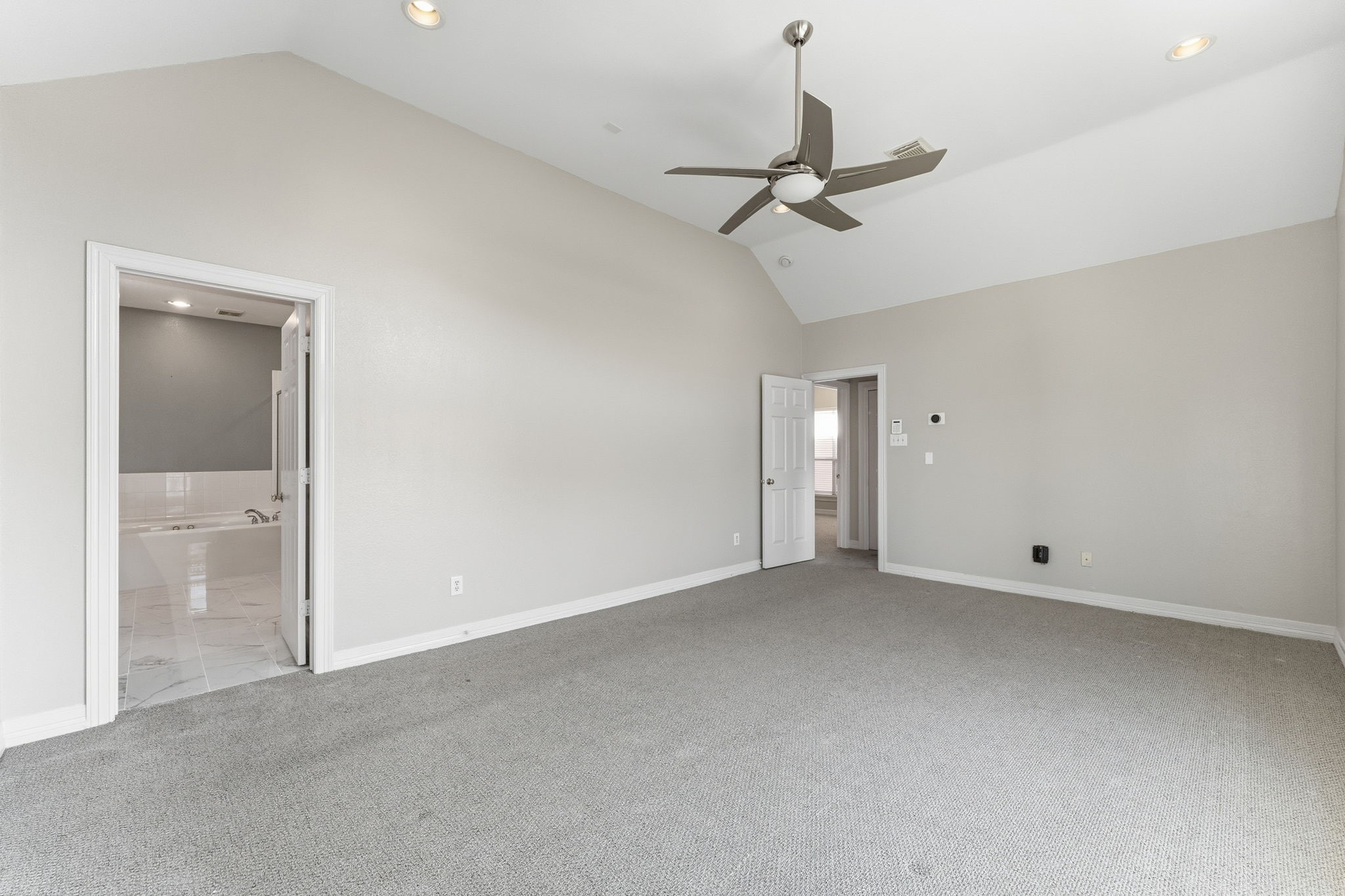 827 Rosine Street Houston, TX 77019 - Photo 38 of 50 This spacious room features a vaulted ceiling, neutral-colored walls, and a ceiling fan. It has an attached bathroom with a sleek design and ample natural light.