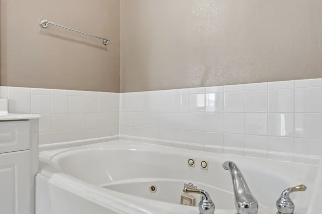 a spacious bathroom with a tub sink and mirror