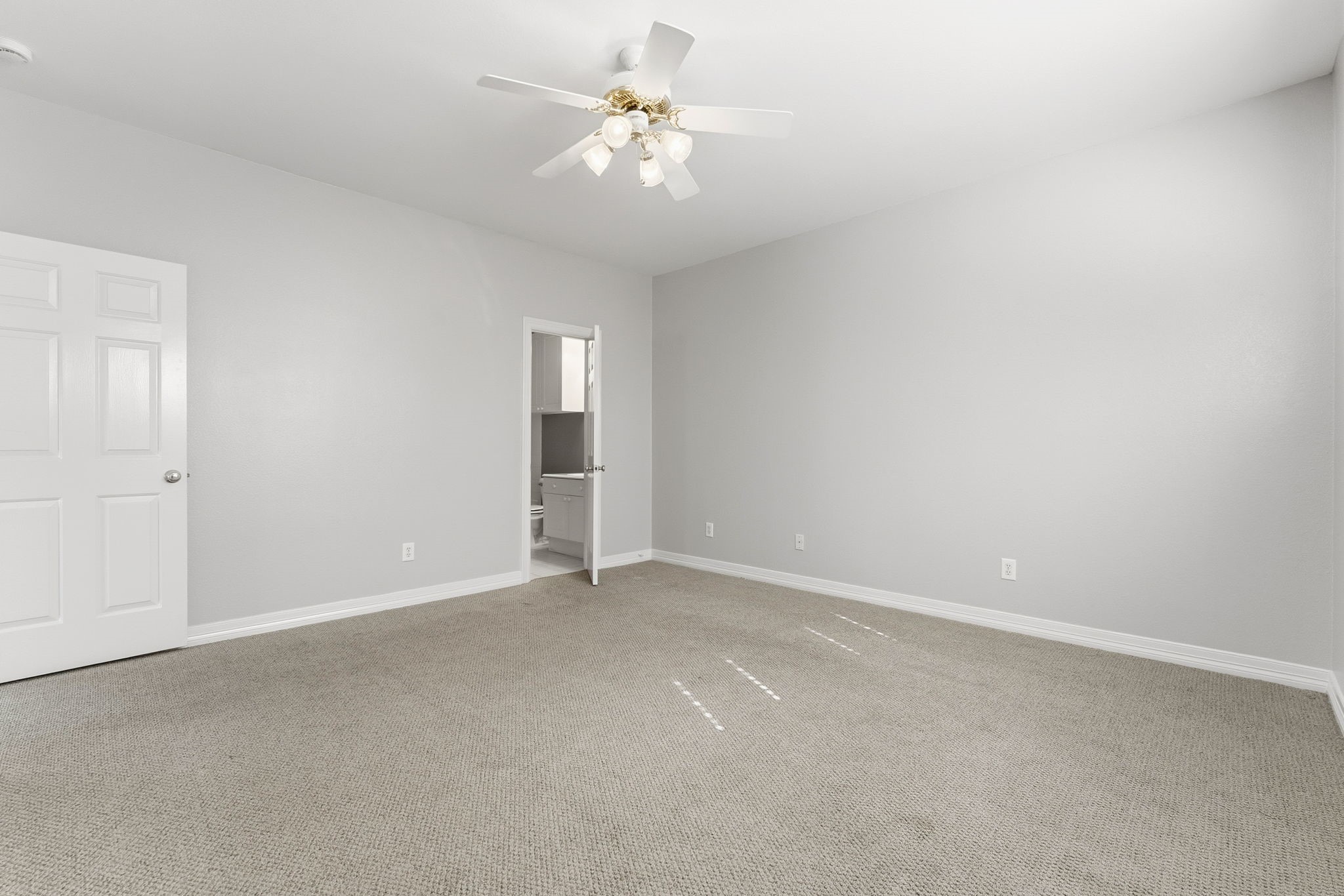 827 Rosine Street Houston, TX 77019 - Photo 48 of 50 This spacious bedroom features neutral walls, carpeted flooring, a ceiling fan, and an en-suite bathroom, providing a comfortable and functional living space.