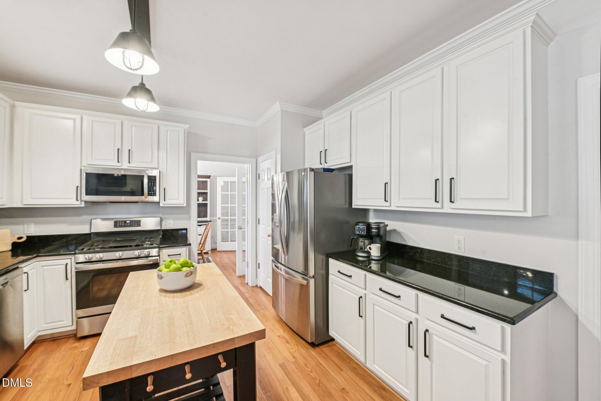 2013 Kinleys Way Raleigh, NC 27613 - Photo 14 of 68 a kitchen with stainless steel appliances a stove a sink a refrigerator white cabinets and wooden floor