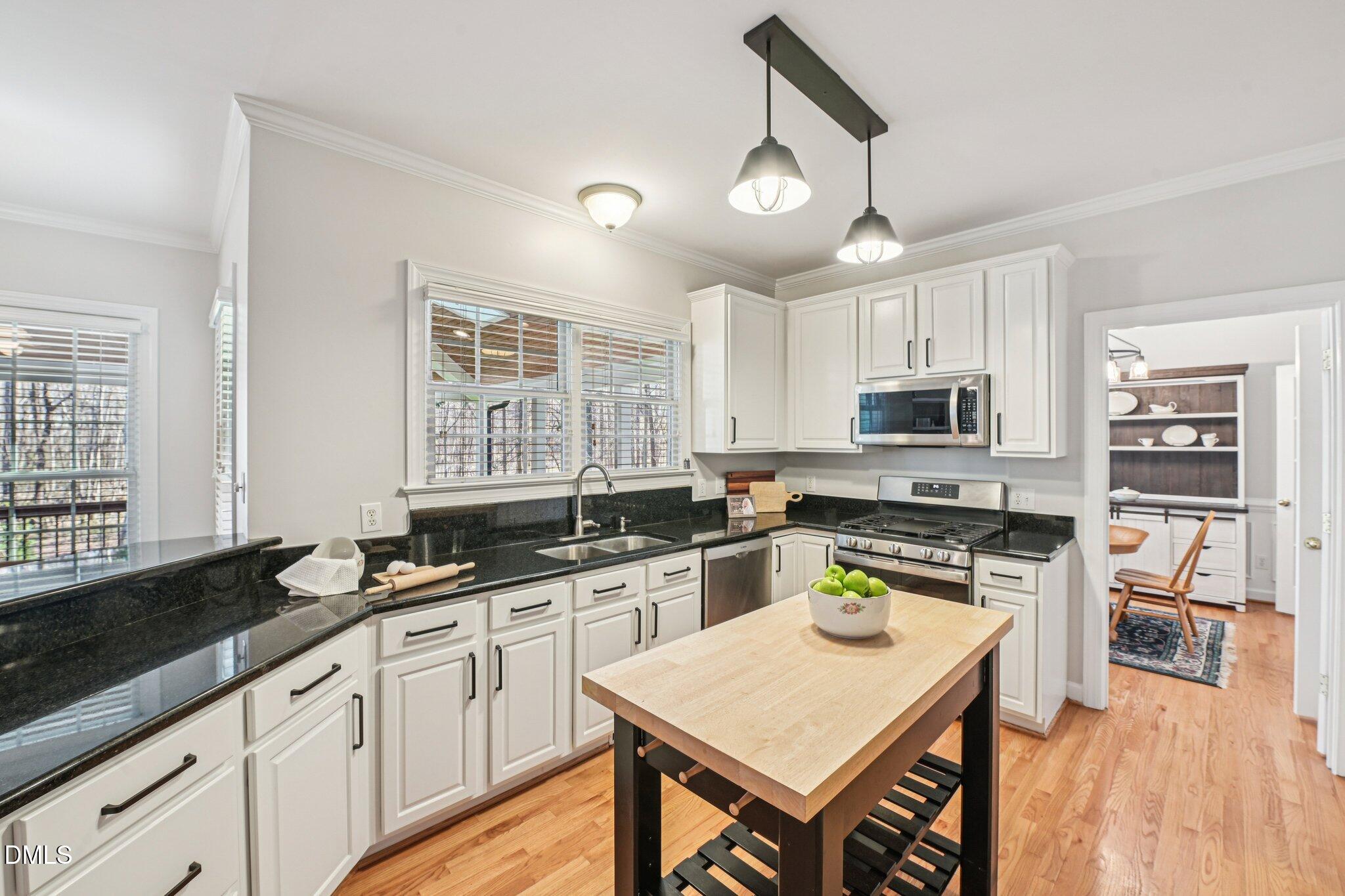 2013 Kinleys Way Raleigh, NC 27613 - Photo 17 of 68 a kitchen with stainless steel appliances granite countertop a stove top oven a sink a stove a dining table and chairs