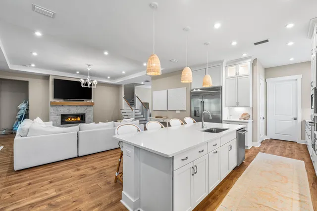 a large white kitchen with a large island oven a sink and a refrigerator