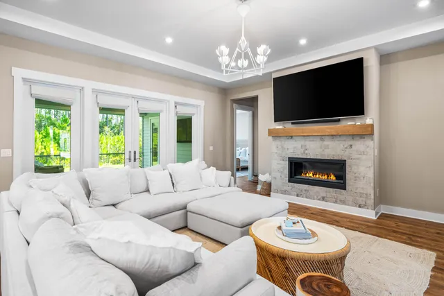 a living room with furniture a flat screen tv and a fireplace