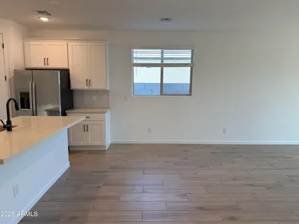 a view of a kitchen with kitchen island a sink wooden floor and a refrigerator
