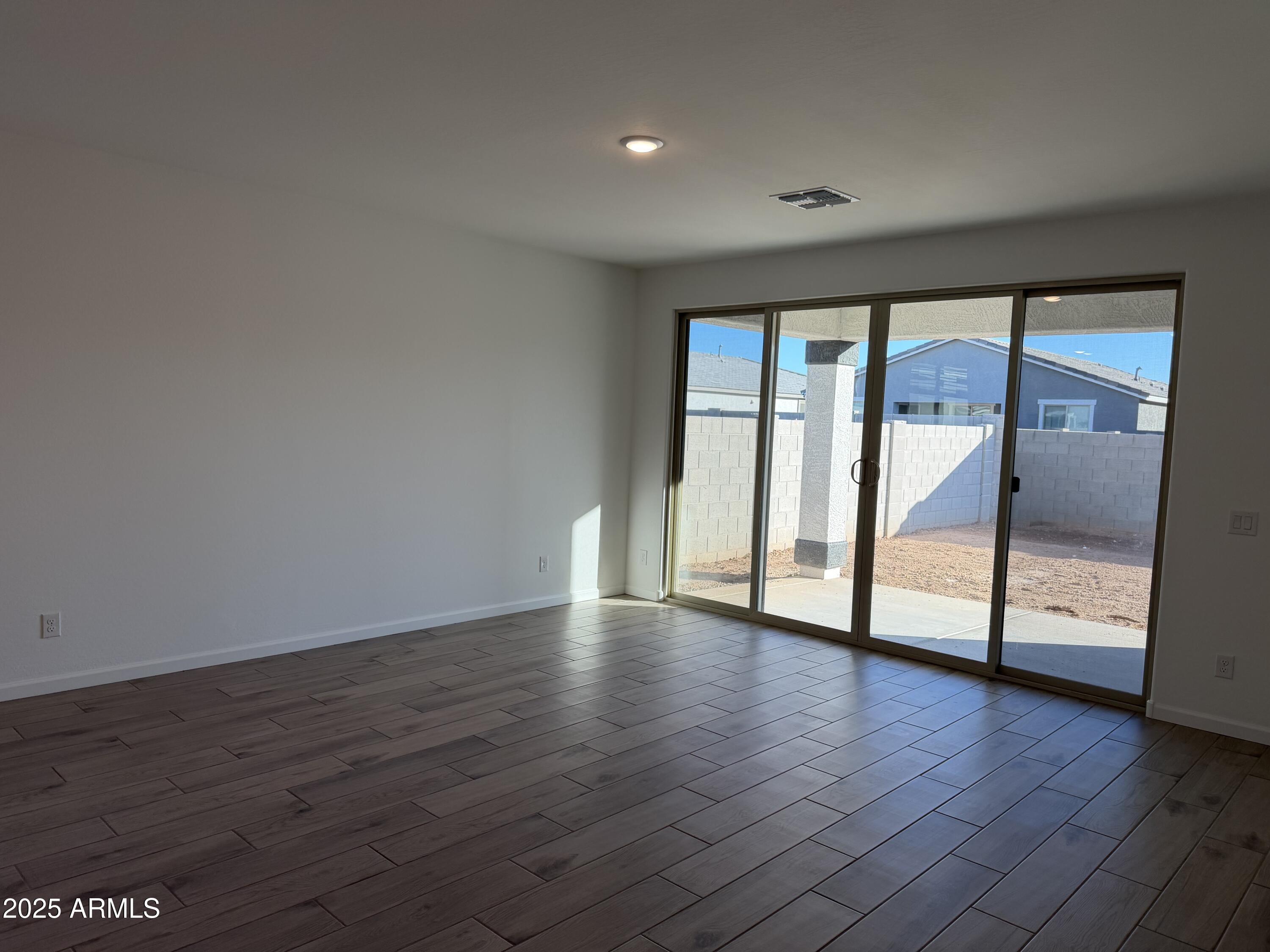 5533 West Buist Avenue Laveen, AZ 85339 - Photo 12 of 42 a view of an empty room with wooden floor and a window