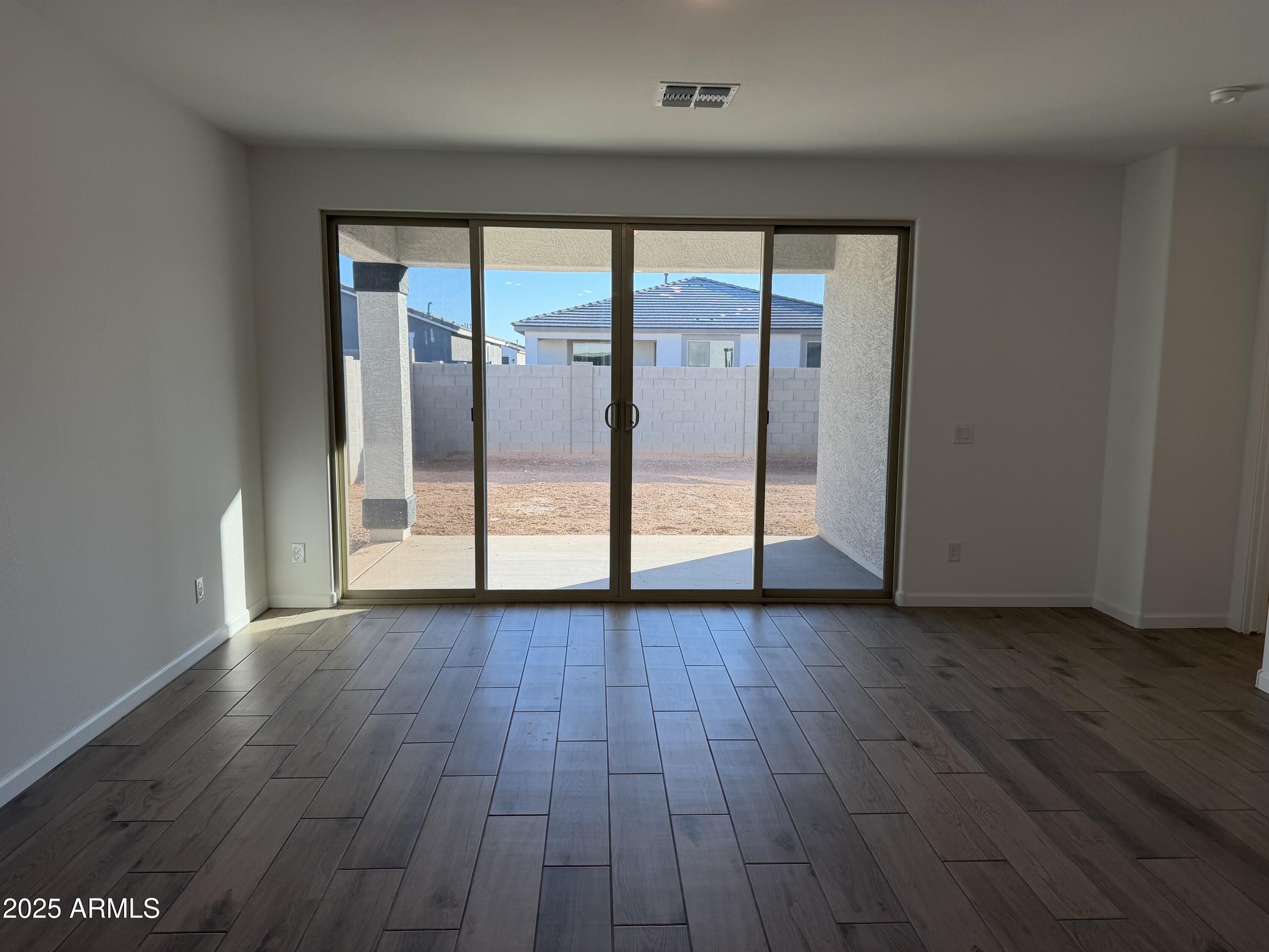 5533 West Buist Avenue Laveen, AZ 85339 - Photo 13 of 42 an empty room with wooden floor and door