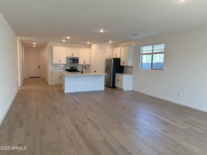 a view of kitchen with kitchen island wooden floor center island and stainless steel appliances
