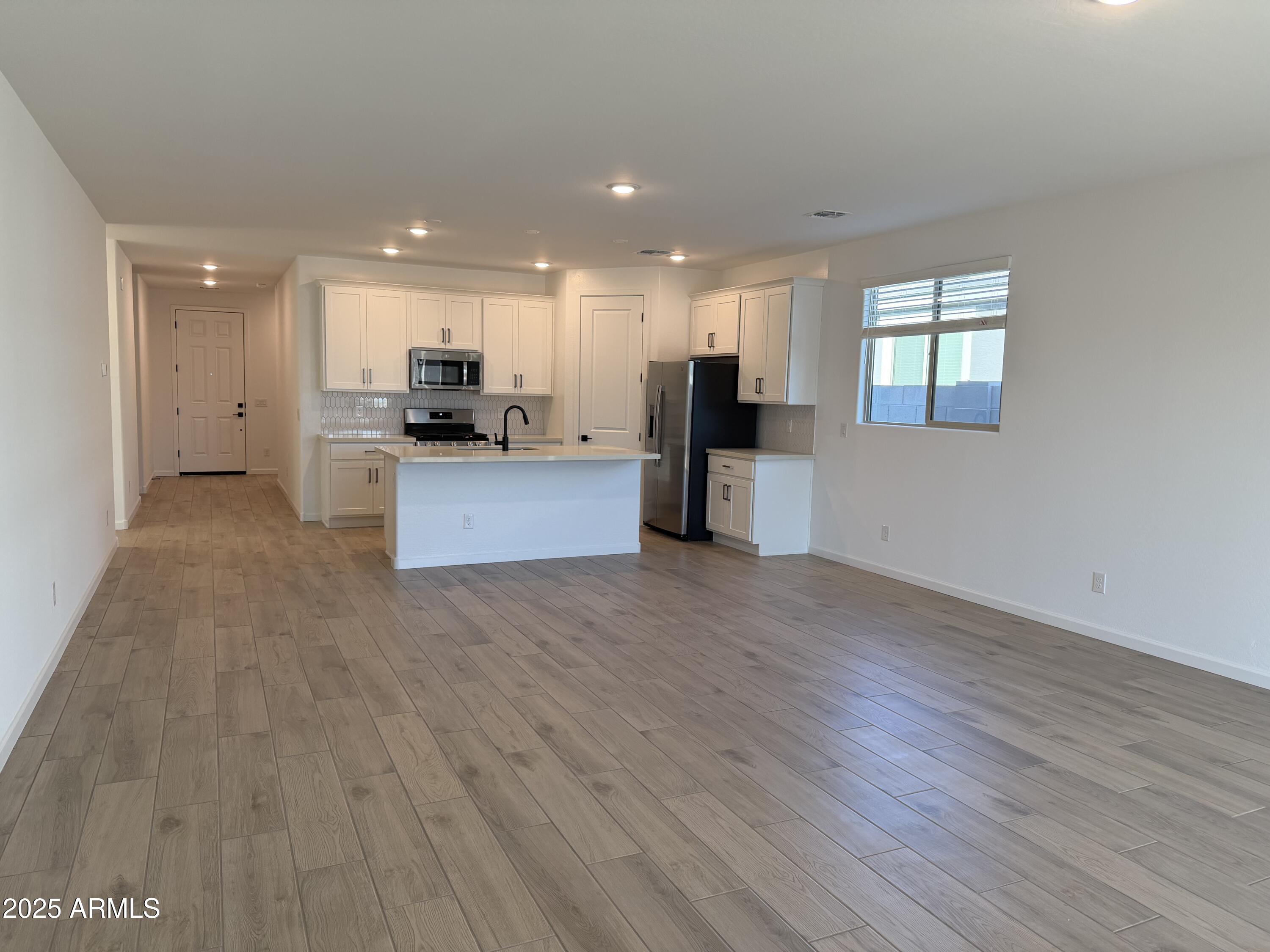 5533 West Buist Avenue Laveen, AZ 85339 - Photo 15 of 42 a view of kitchen with kitchen island wooden floor center island and stainless steel appliances