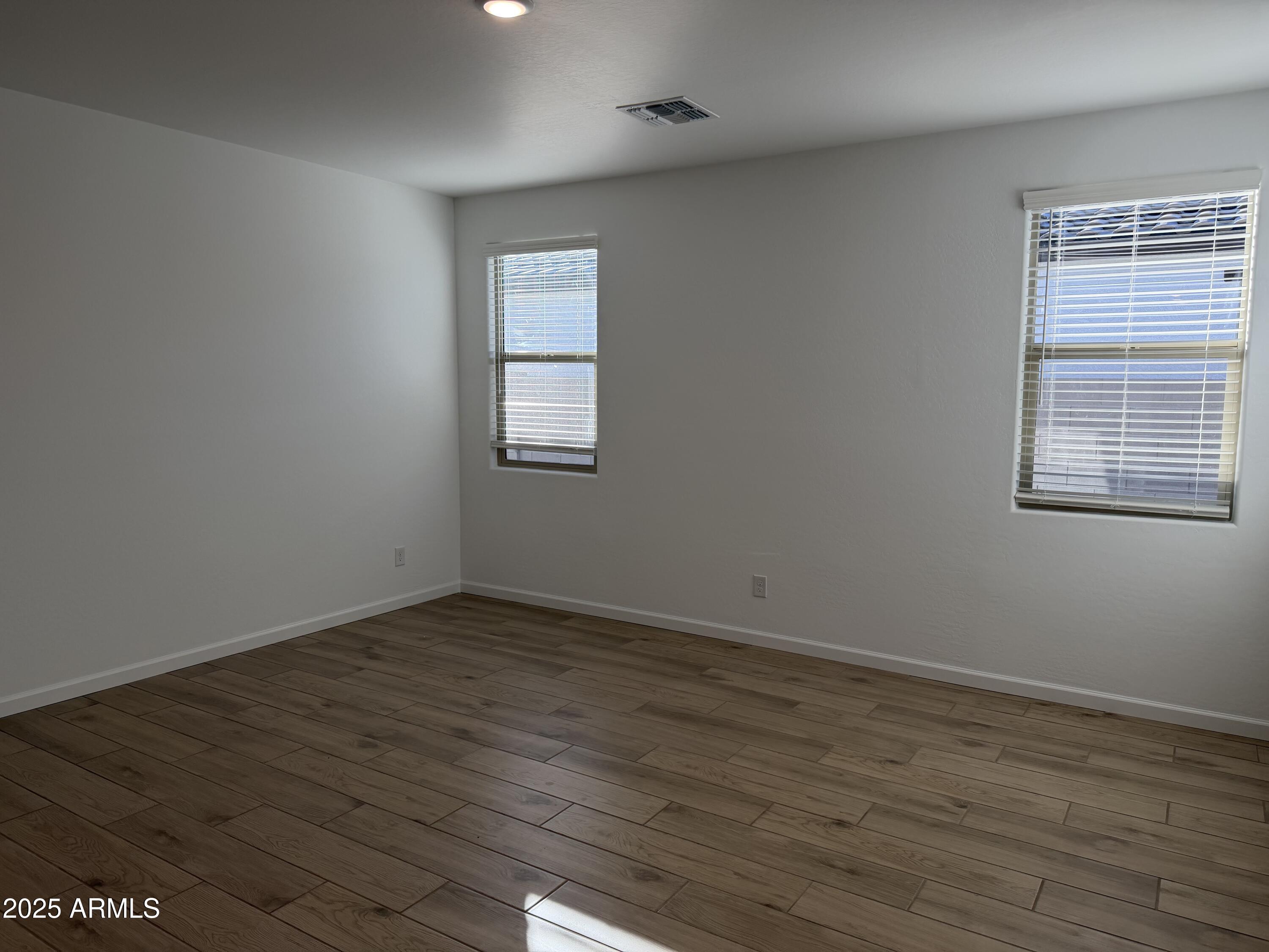 5533 West Buist Avenue Laveen, AZ 85339 - Photo 22 of 42 a view of an empty room with wooden floor and a window