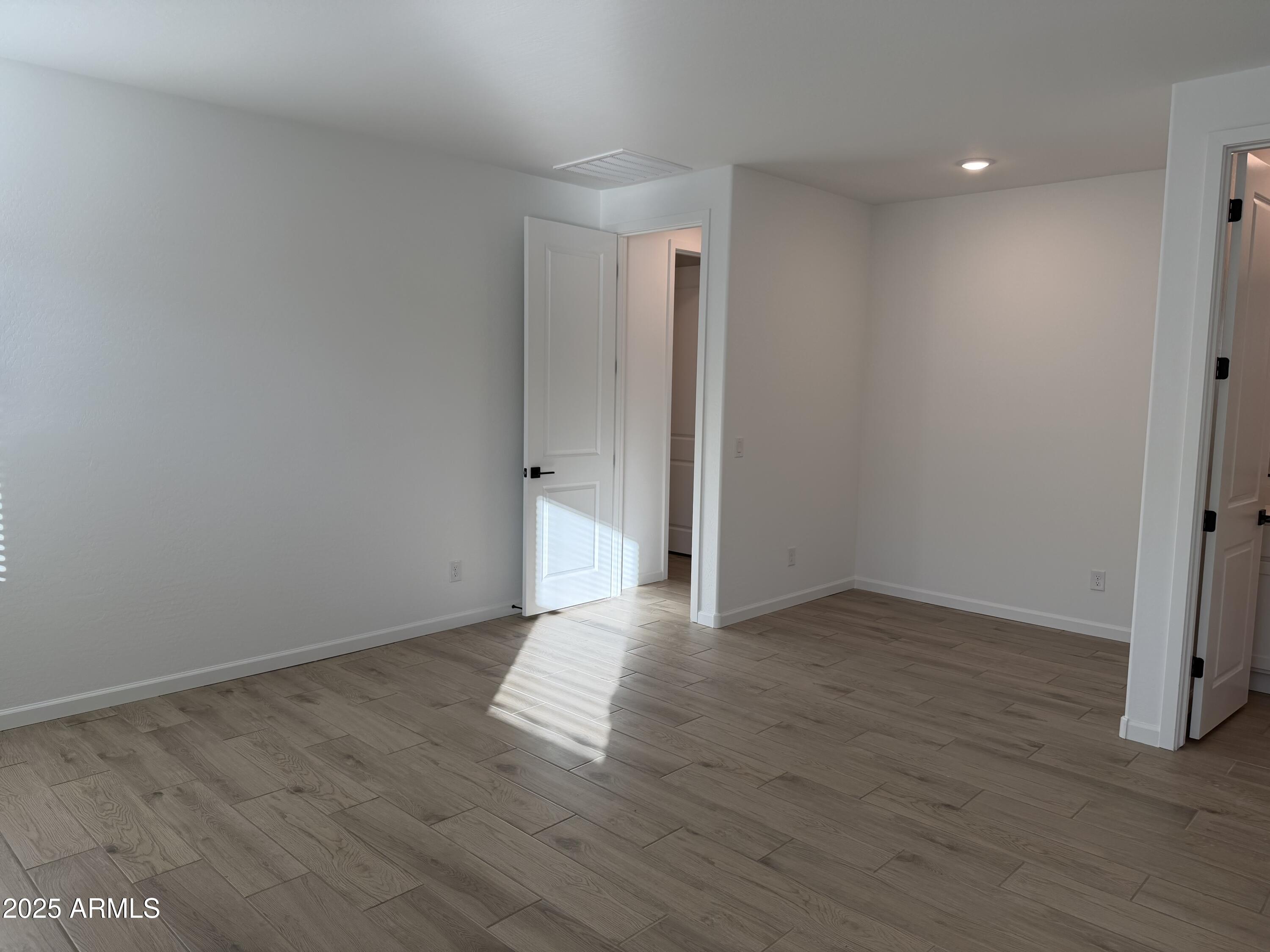 5533 West Buist Avenue Laveen, AZ 85339 - Photo 24 of 42 a view of an empty room with wooden floor and closet