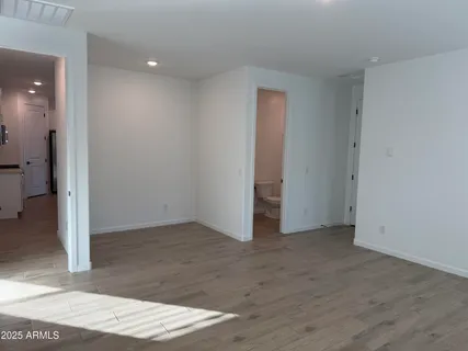 an empty room with wooden floor and a bathroom