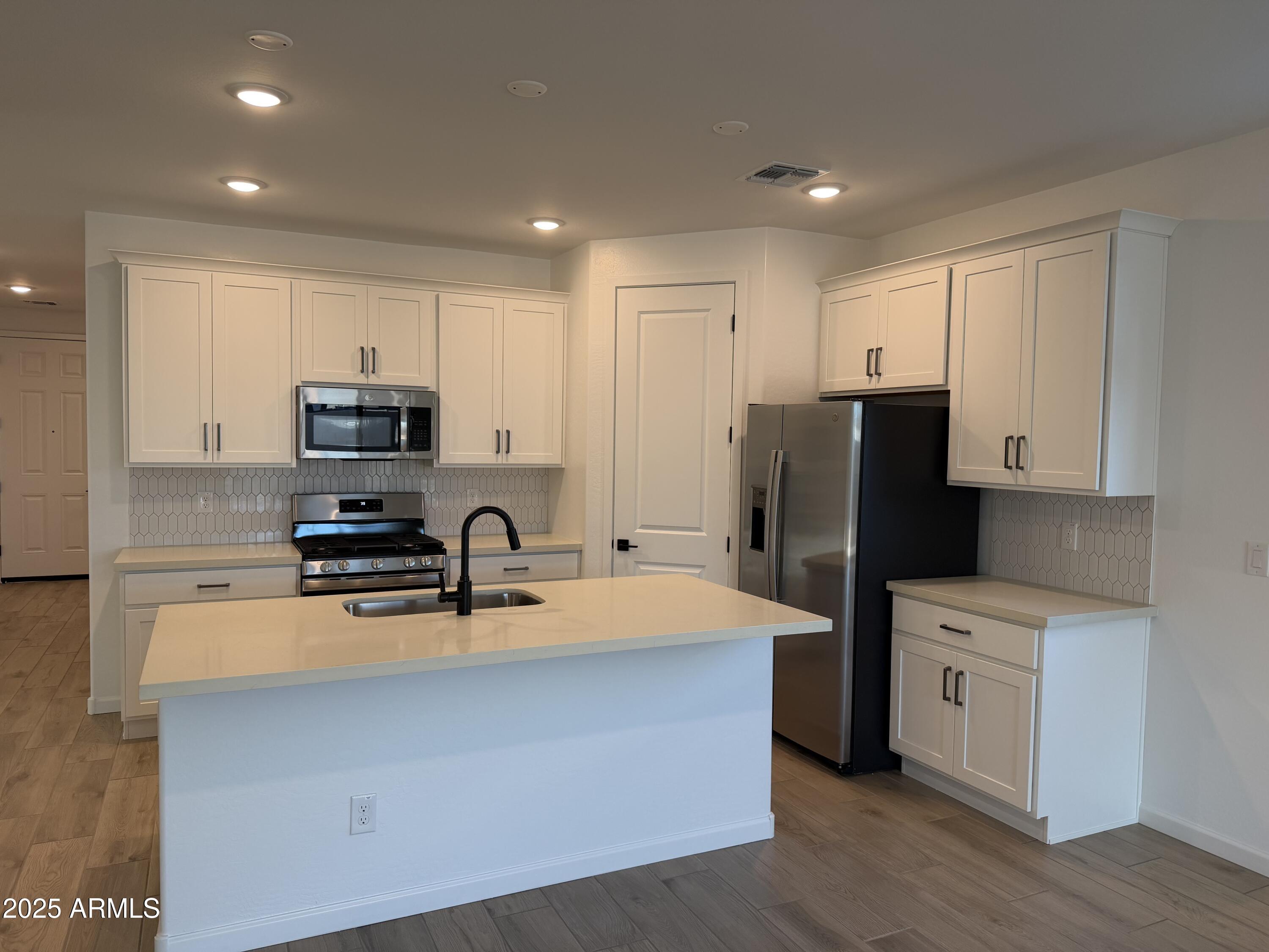 5533 West Buist Avenue Laveen, AZ 85339 - Photo 8 of 42 a kitchen with stainless steel appliances a refrigerator sink microwave and cabinets