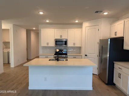 a kitchen with wooden cabinets and stainless steel appliances