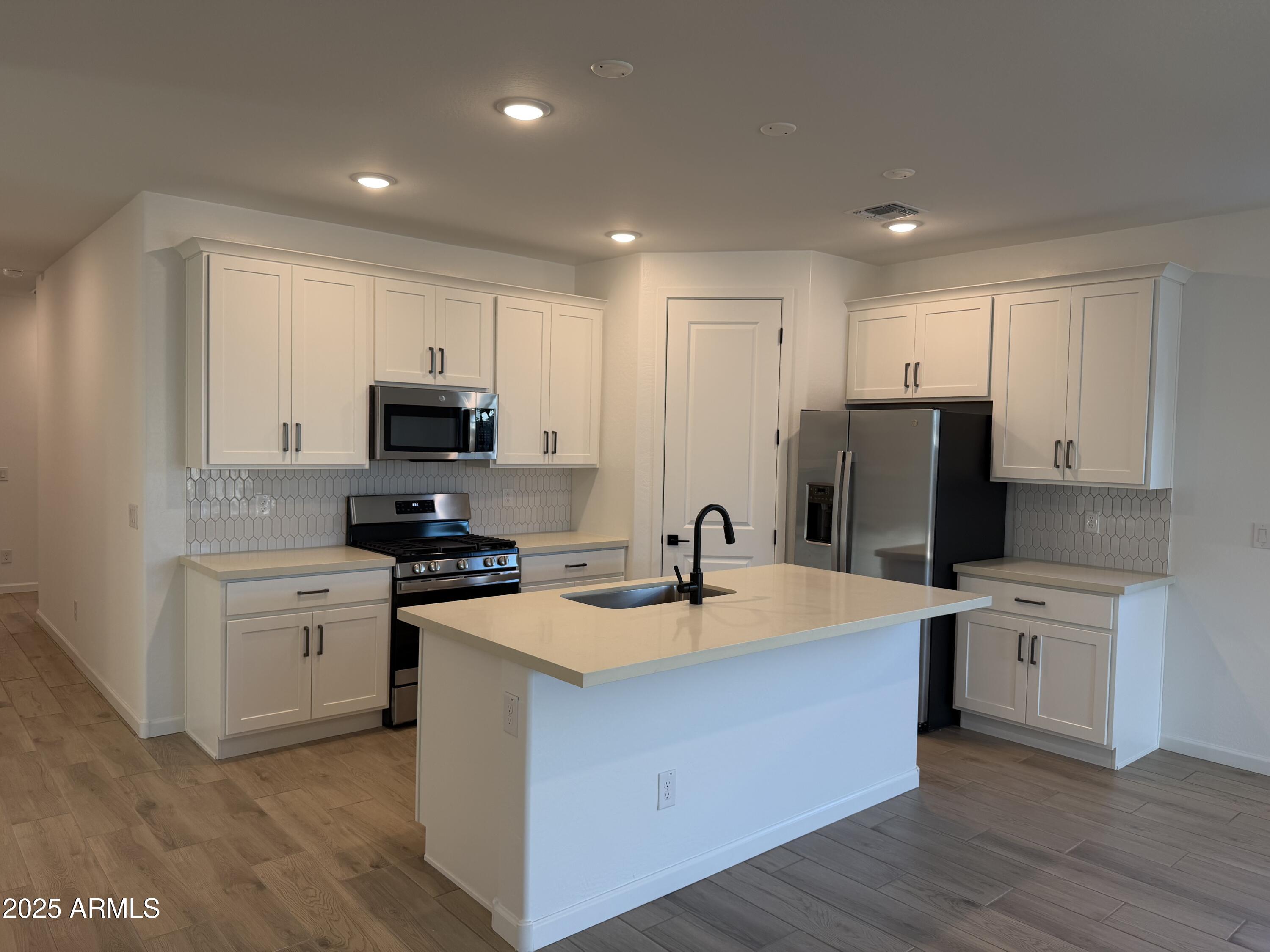 5533 West Buist Avenue Laveen, AZ 85339 - Photo 10 of 42 a kitchen with a sink a stove a refrigerator a center island and a window
