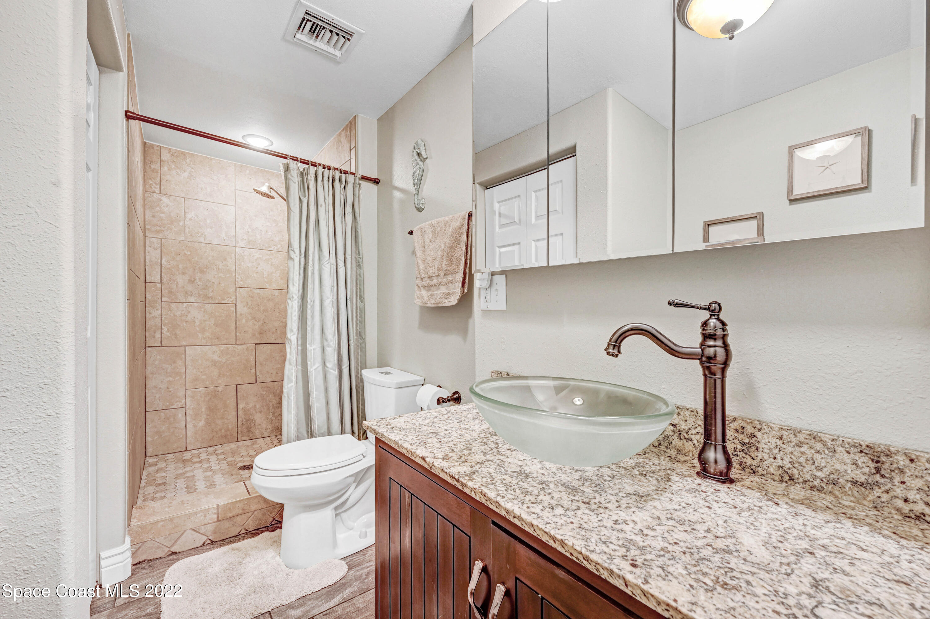 1304 Lichty Street Palm Bay, FL 32905 - Photo 18 of 57 a bathroom with a granite countertop sink a toilet and shower