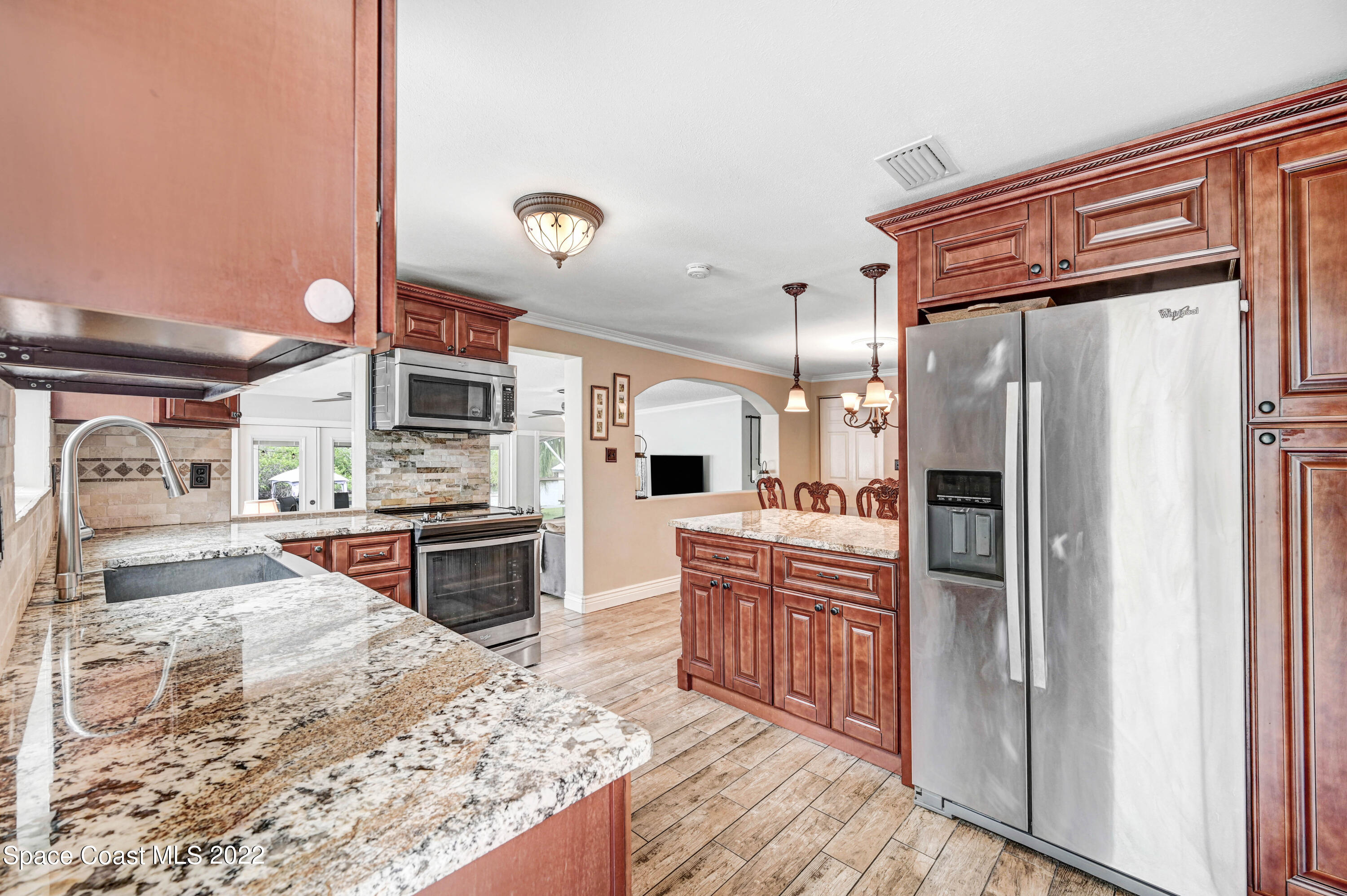 1304 Lichty Street Palm Bay, FL 32905 - Photo 5 of 57 a large kitchen with stainless steel appliances kitchen island granite countertop a refrigerator and stove top oven