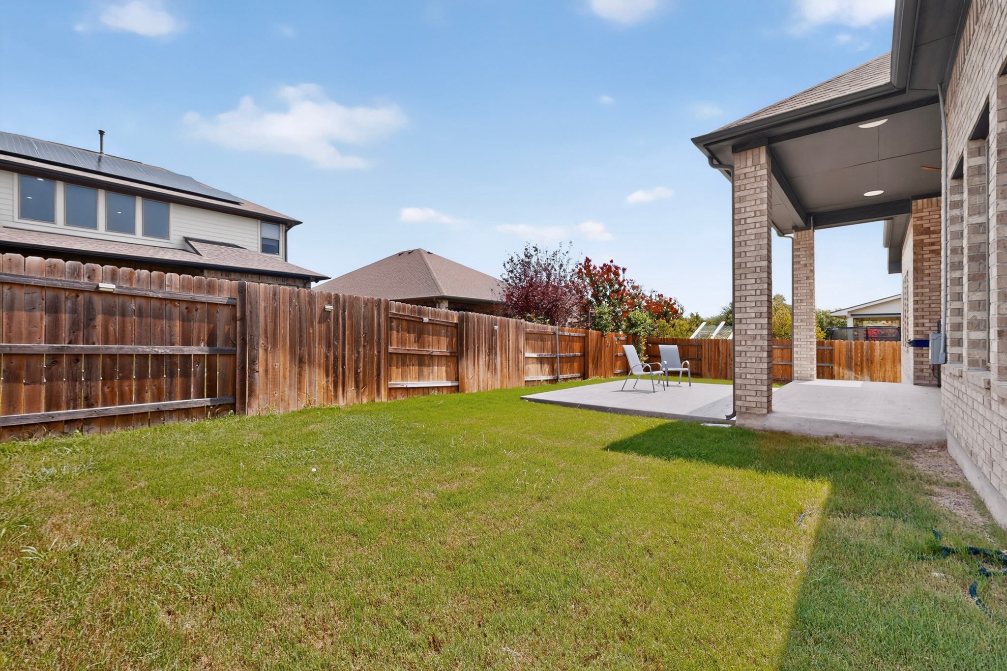 2433 La Mirada Street Leander, TX 78641 - Photo 24 of 25 A spacious, enclosed backyard offers a covered patio and ample green space for outdoor enjoyment.