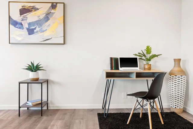 a view of a workspace with furniture and wooden floor