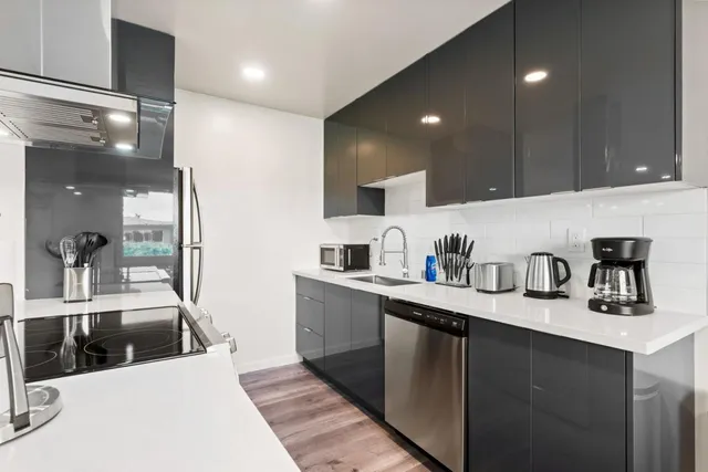 a kitchen with stainless steel appliances granite countertop a sink a stove and cabinets