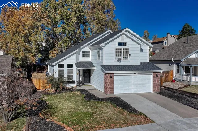 a view of a house with a yard and large tree