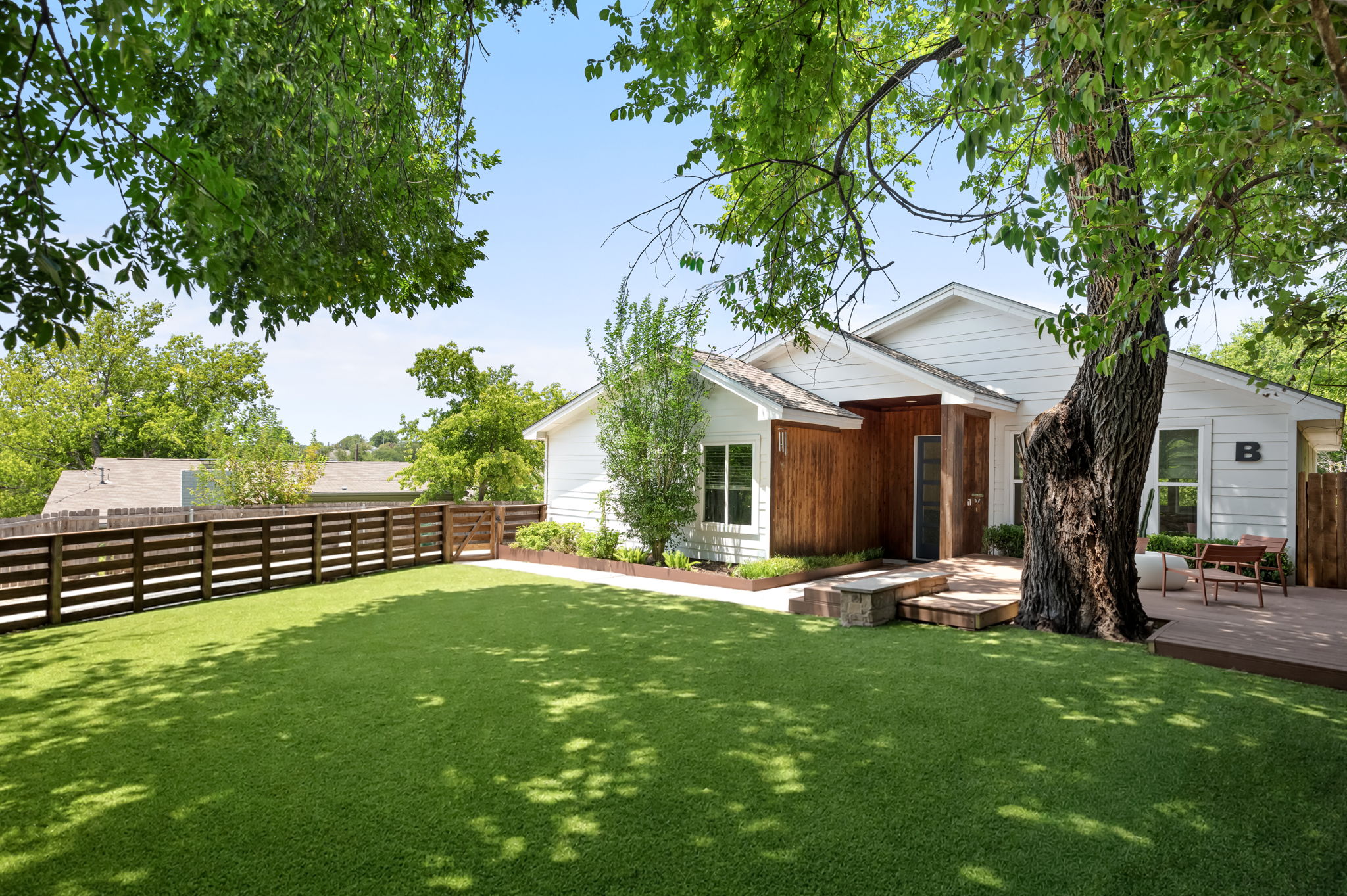 1902 Webberville Road, Unit B Austin, TX 78721 - Photo 36 of 39 A private yard with a large deck and wood fencing surrounds this charming white house.