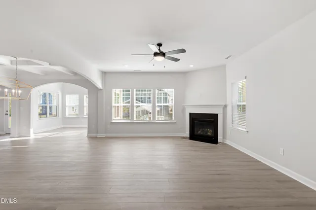 a view of a big room with wooden floor and windows