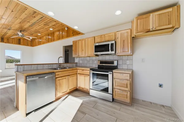 a kitchen with stainless steel appliances granite countertop a stove top oven a sink and dishwasher