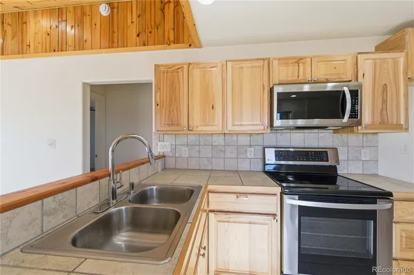 a kitchen with a sink stove top oven and microwave