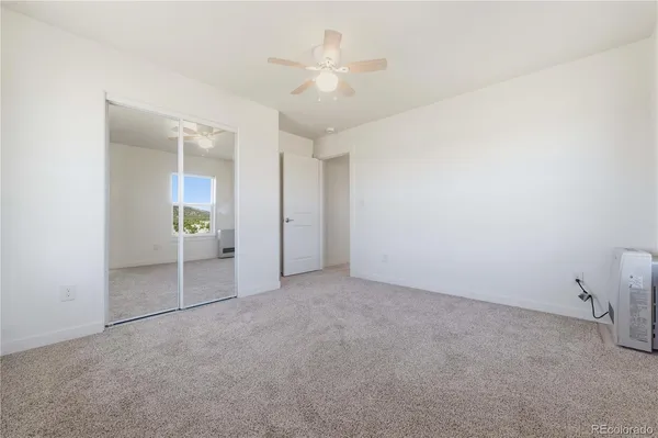 an empty room with fan and entrance