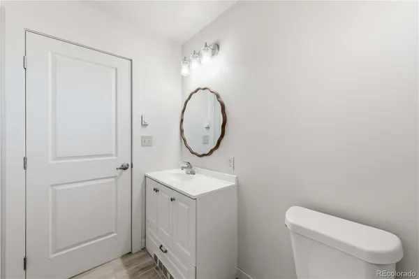 a bathroom with a toilet a sink and a mirror