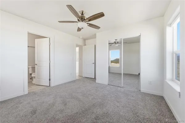 an empty room with closet and windows