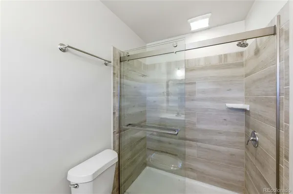 a bathroom with a shower a toilet and a sink