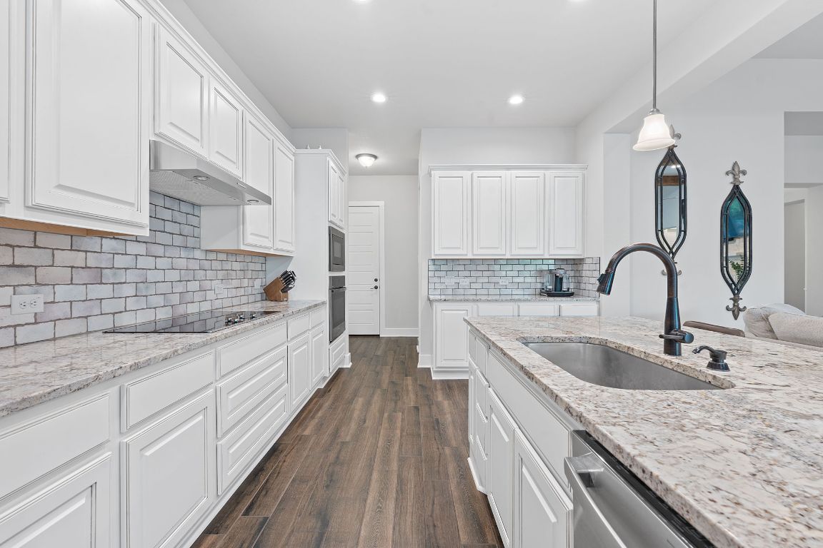 159 Raptor Beak Way Cedar Creek, TX 78612 - Photo 11 of 31 a large kitchen with granite countertop a sink and cabinets