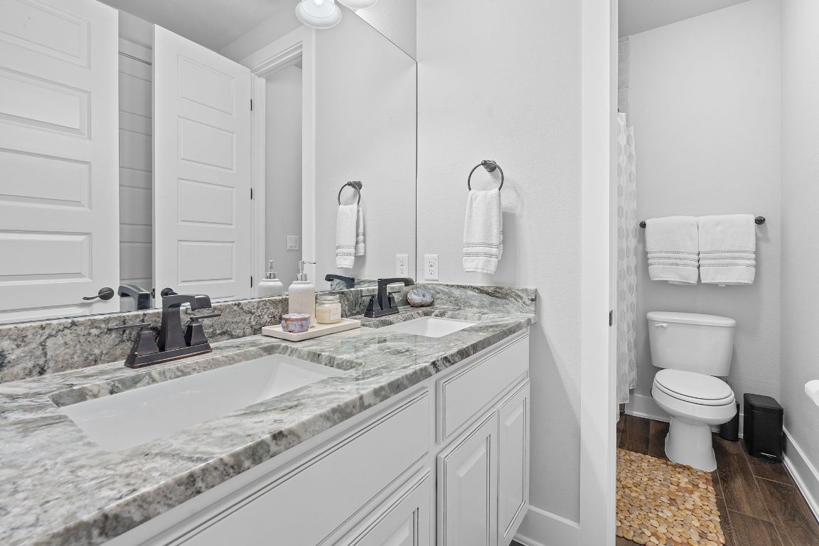 159 Raptor Beak Way Cedar Creek, TX 78612 - Photo 22 of 31 a bathroom with a granite countertop sink mirror and toilet