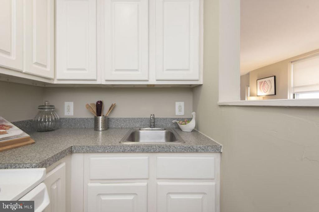 201 South 13th Street, Unit 801 Philadelphia, PA 19107 - Photo 9 of 18 a kitchen with granite countertop white cabinets and a sink