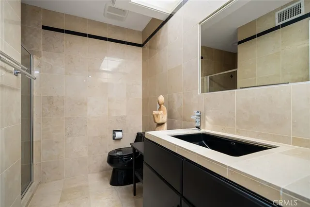 a living room with couches a flat screen tv and kitchen view