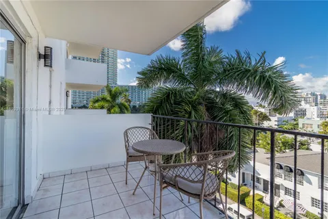 a view of a chair and table in patio with potted plants