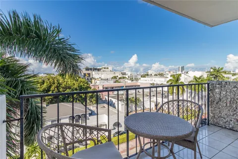 a view of a balcony with wooden floor and outdoor seating