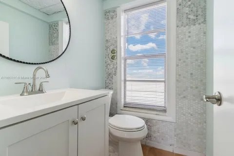 a bathroom with a sink a toilet and a mirror