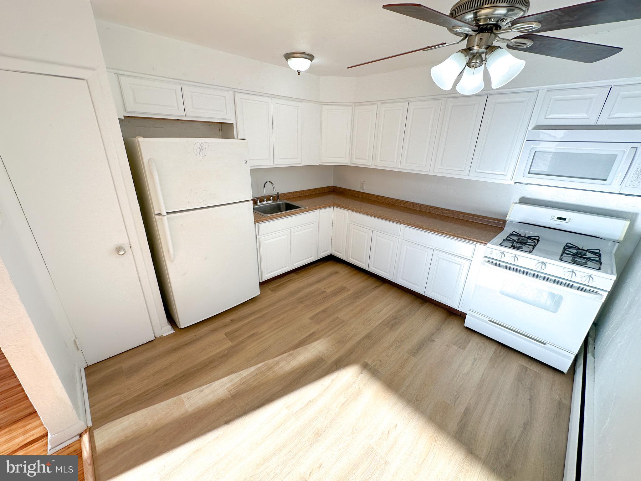 a kitchen with a sink stainless steel appliances a refrigerator and a stove