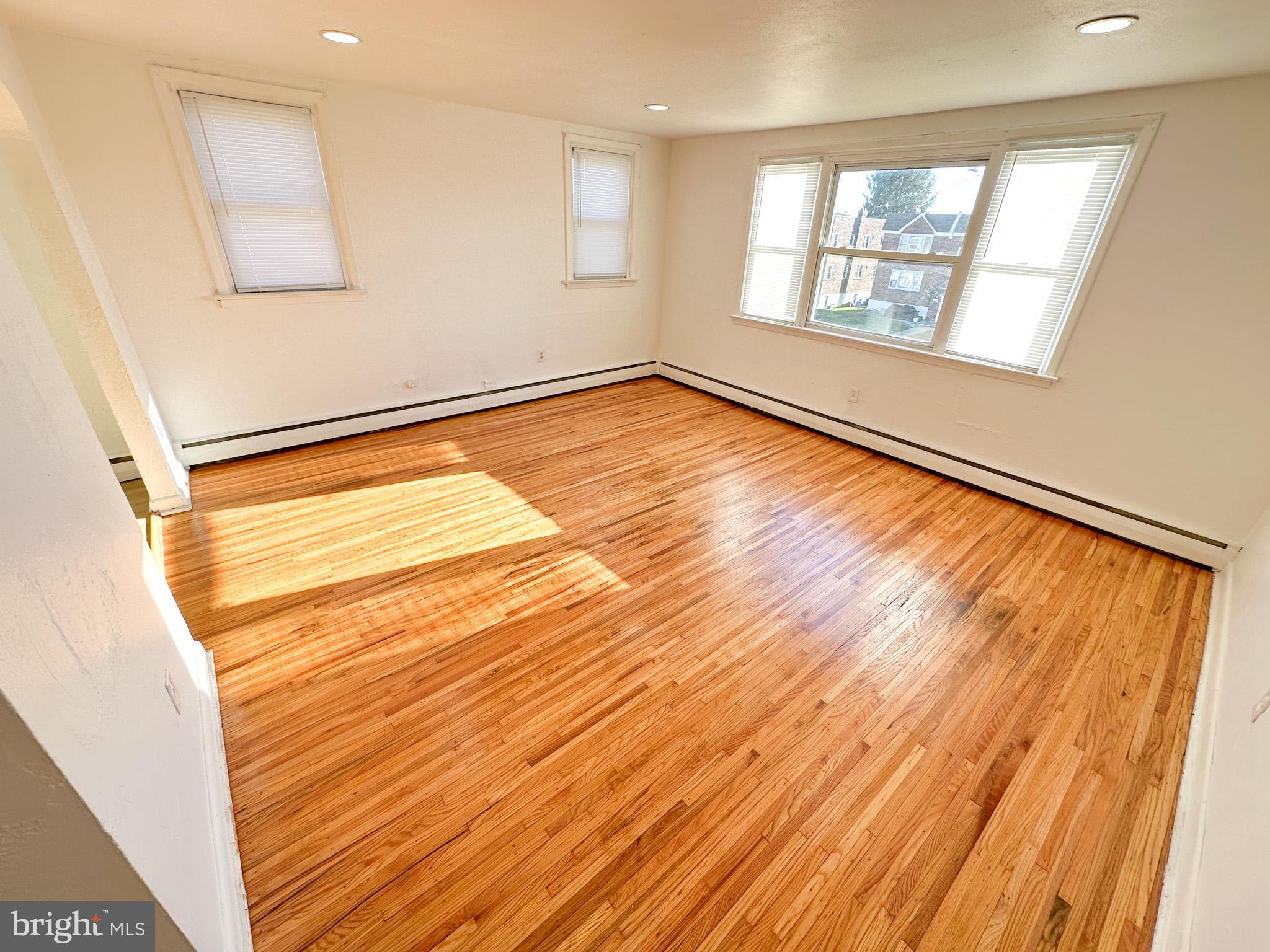 1205-7 Princeton Avenue, Unit C Philadelphia, PA 19111 - Photo 3 of 15 a view of an empty room with wooden floor and a window