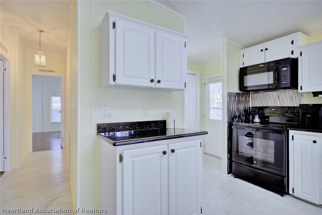 2702 Rodney Street Sebring, FL 33872 - Photo 9 of 33 a kitchen with stainless steel appliances granite countertop a stove a sink and a refrigerator
