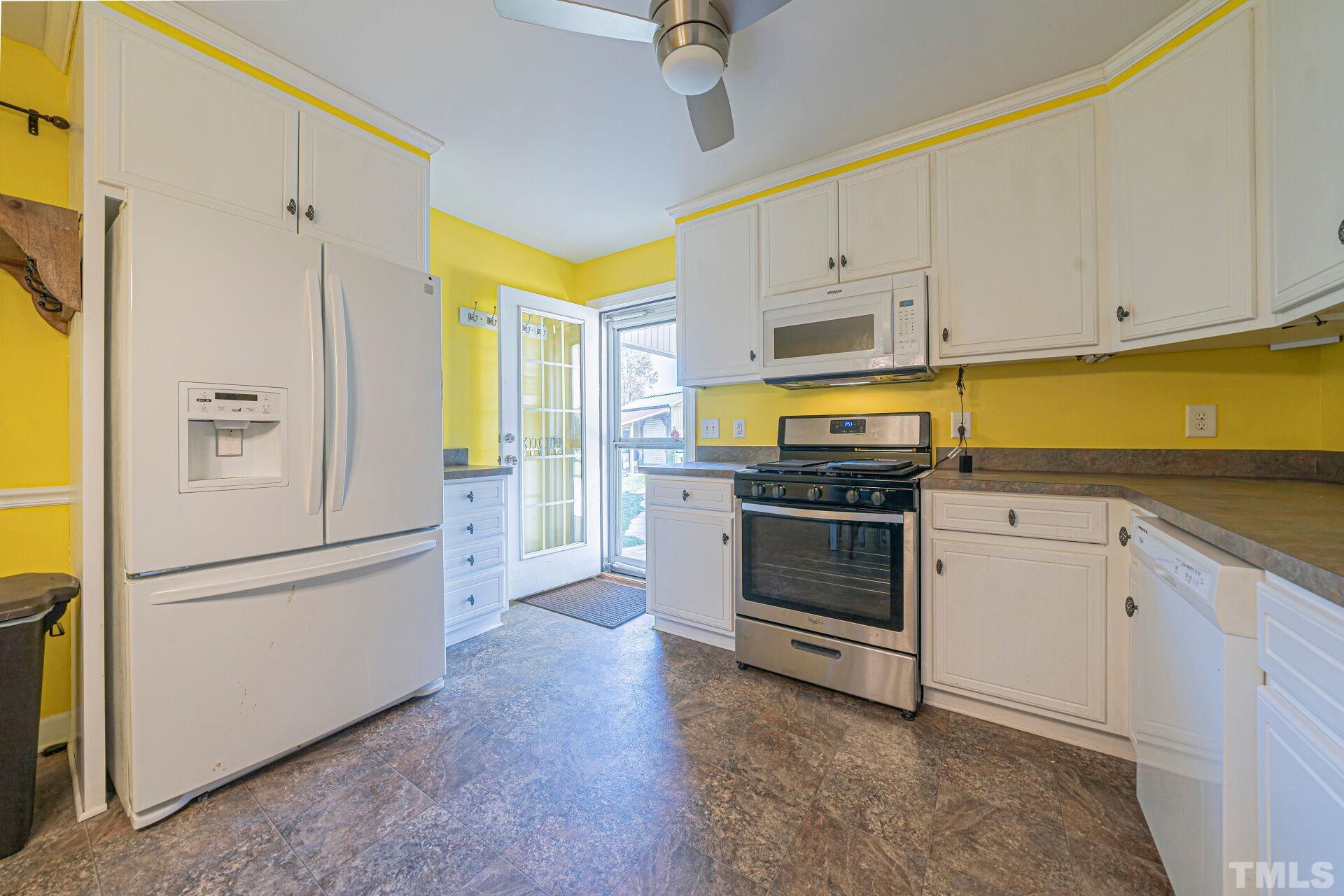 7039 Stokes Road Middlesex, NC 27557 - Photo 3 of 25 a kitchen with a refrigerator and a stove top oven