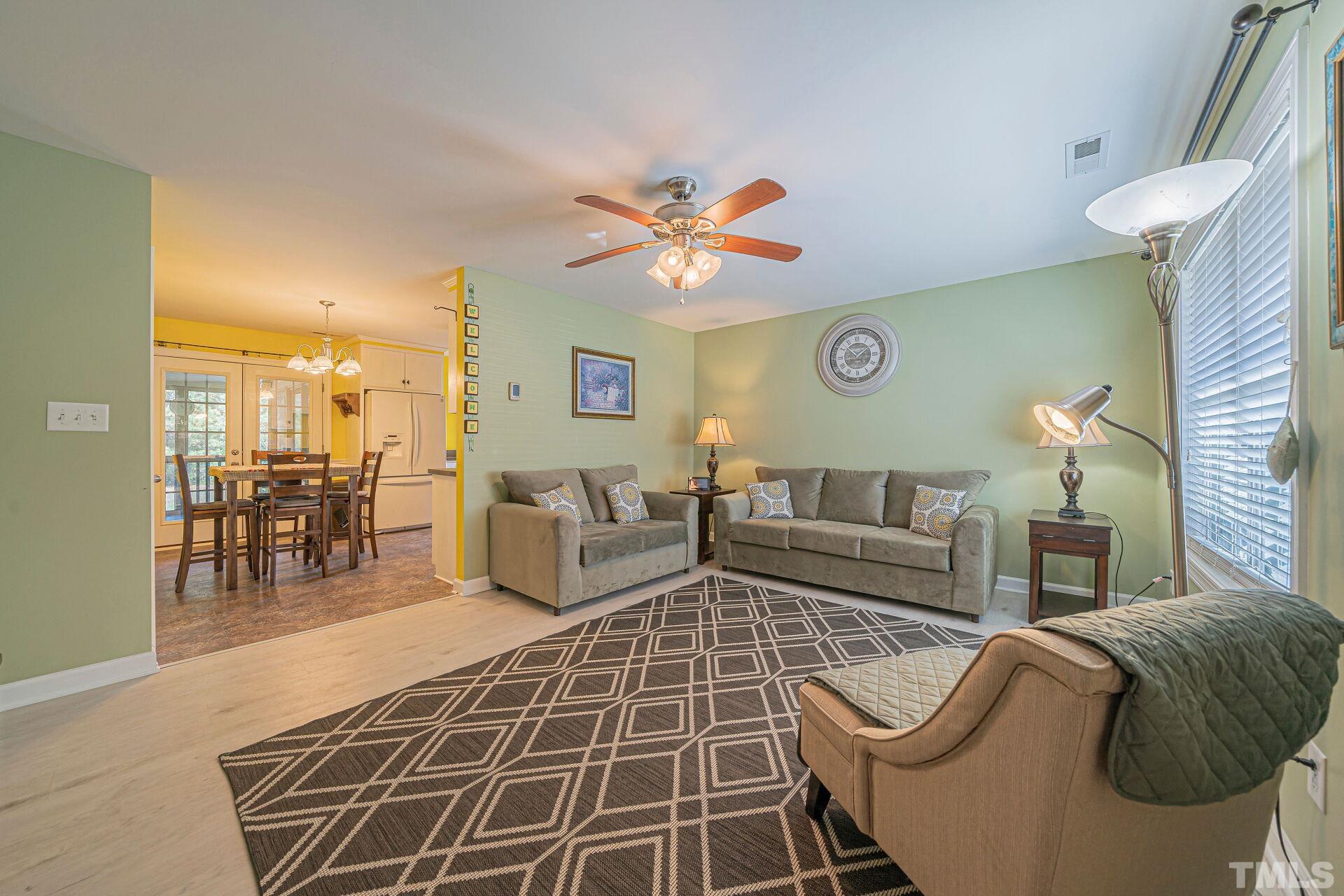 7039 Stokes Road Middlesex, NC 27557 - Photo 8 of 25 a living room with furniture a rug and a chandelier